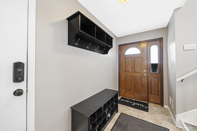 foyer entrance with stone finish flooring and baseboards