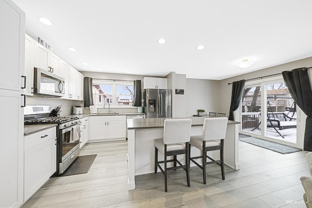 kitchen featuring a healthy amount of sunlight, a breakfast bar area, stainless steel appliances, and a center island