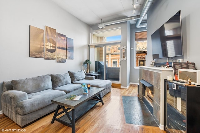 living area featuring baseboards, light wood-style floors, and a fireplace