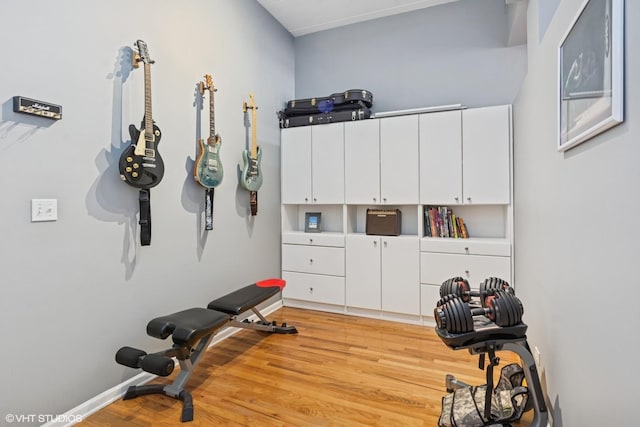 workout area with baseboards and light wood-style floors