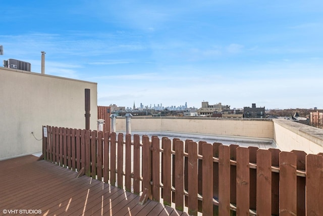 wooden deck featuring a city view and cooling unit