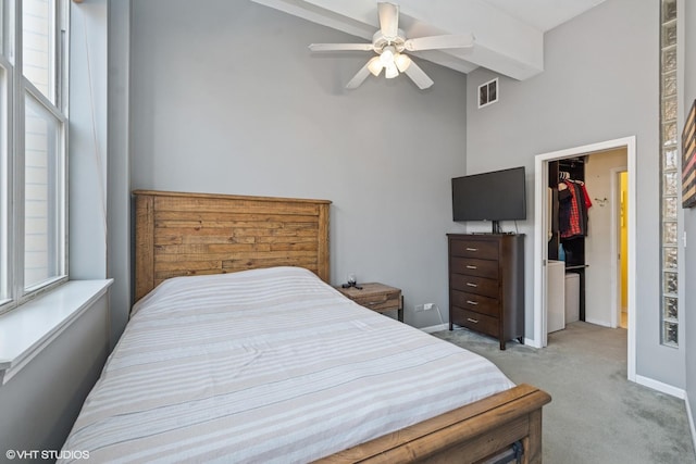 bedroom with visible vents, multiple windows, light colored carpet, and a walk in closet