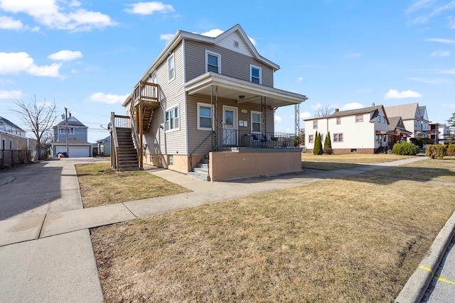 view of front of property featuring stairway, a residential view, covered porch, and a front lawn