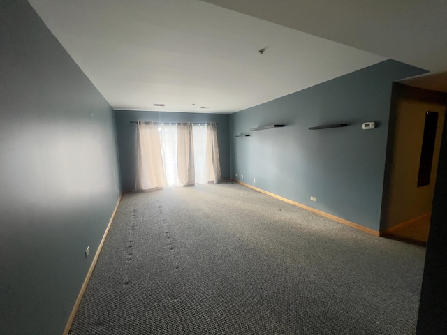 unfurnished room with baseboards and carpet flooring