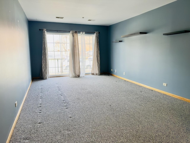 carpeted empty room featuring visible vents and baseboards