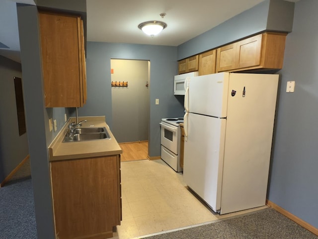 kitchen featuring baseboards, light floors, light countertops, white appliances, and a sink