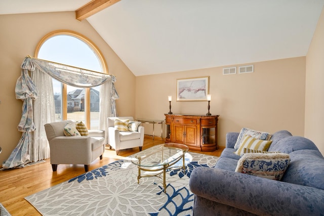 living area with beam ceiling, visible vents, high vaulted ceiling, and wood finished floors