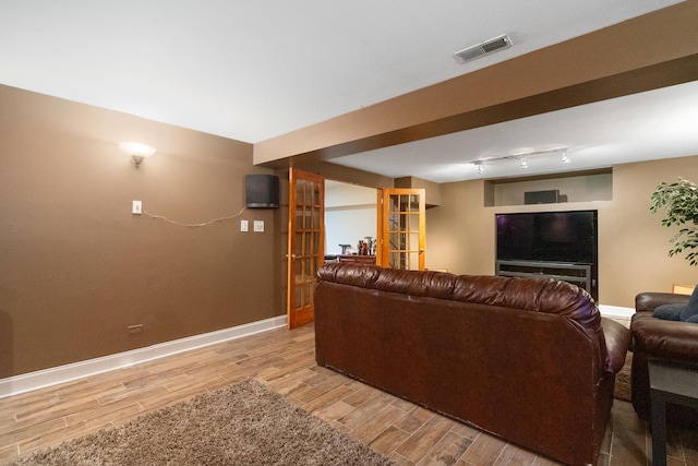 living area featuring track lighting, baseboards, visible vents, and wood tiled floor