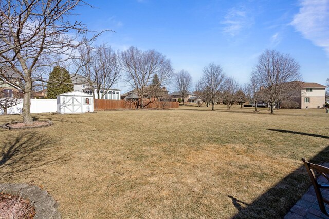 view of yard with an outdoor structure, a storage unit, and fence