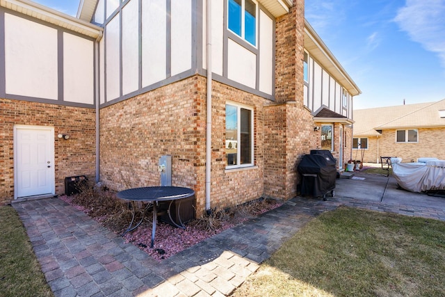 view of home's exterior with a patio and brick siding