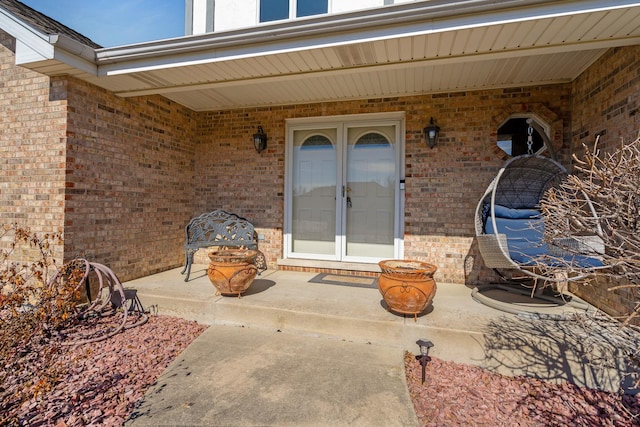 property entrance with brick siding and a patio area