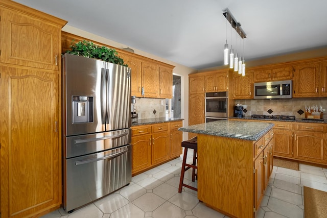 kitchen with decorative backsplash, brown cabinets, a kitchen island, and appliances with stainless steel finishes