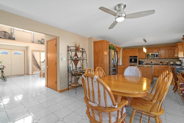 dining area with light tile patterned floors, stairway, baseboards, and ceiling fan