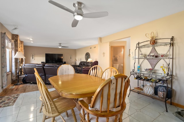 dining space with ceiling fan, baseboards, and light tile patterned flooring