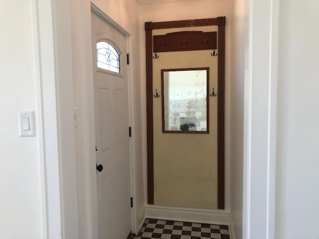 doorway to outside with baseboards and tile patterned floors