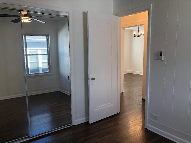 unfurnished bedroom featuring dark wood-style flooring and baseboards