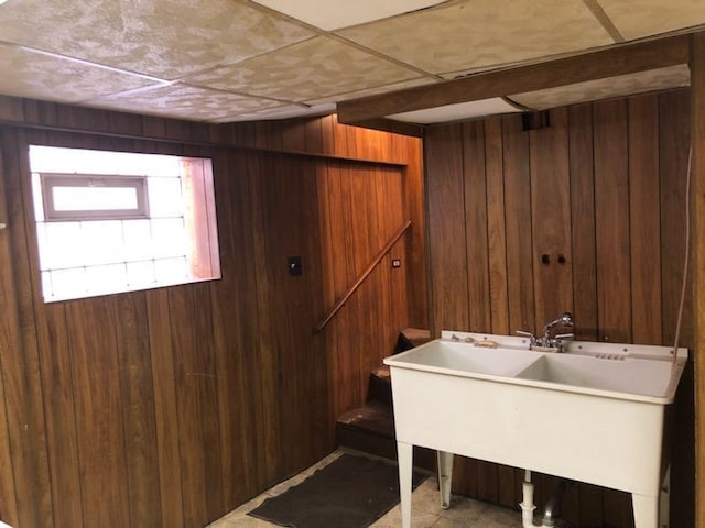 laundry room with wood walls and a sink