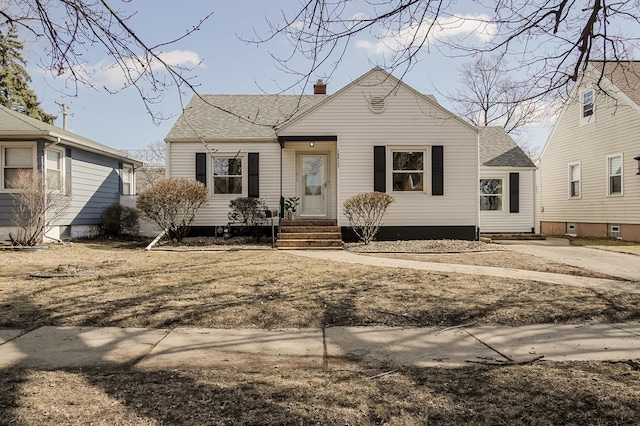 bungalow-style house featuring a chimney and roof with shingles