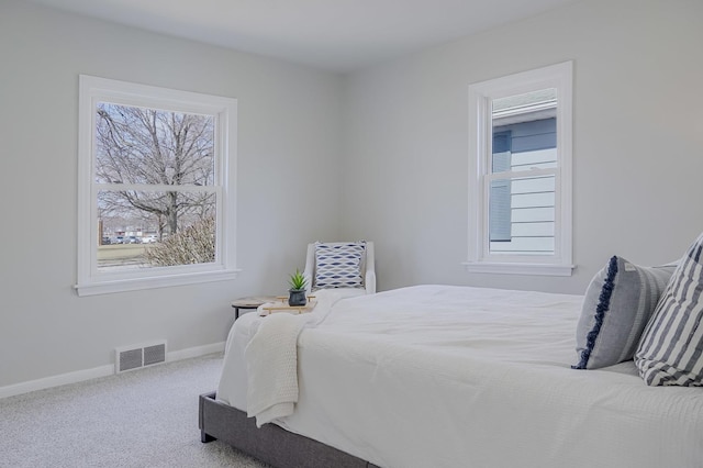 carpeted bedroom featuring visible vents and baseboards