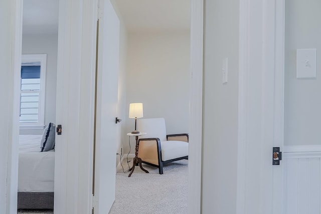 corridor featuring wainscoting and light colored carpet