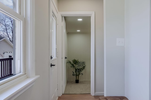 corridor featuring baseboards, light wood-type flooring, and recessed lighting