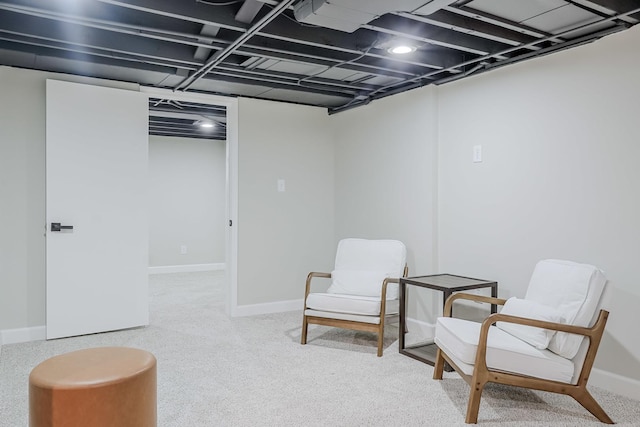 living area with light colored carpet and baseboards