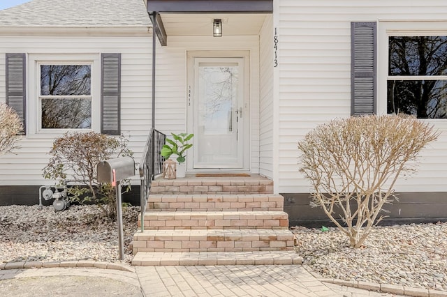 doorway to property featuring a shingled roof