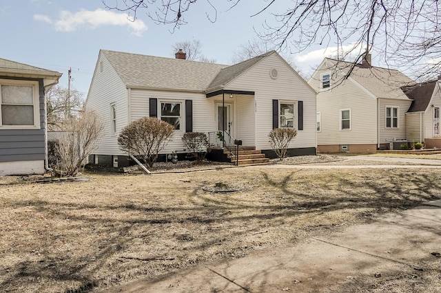 view of front of home with a chimney, cooling unit, and roof with shingles