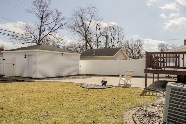 view of yard featuring cooling unit, fence, an outbuilding, and a patio