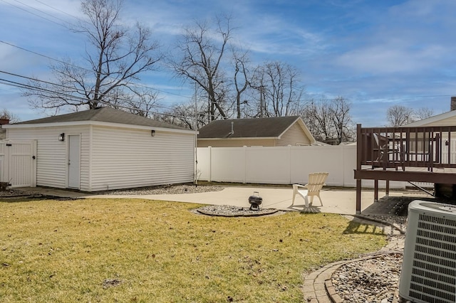 view of yard featuring an outbuilding, a patio area, fence, and central air condition unit