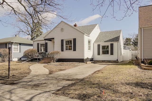 bungalow-style home featuring a gate, roof with shingles, and fence