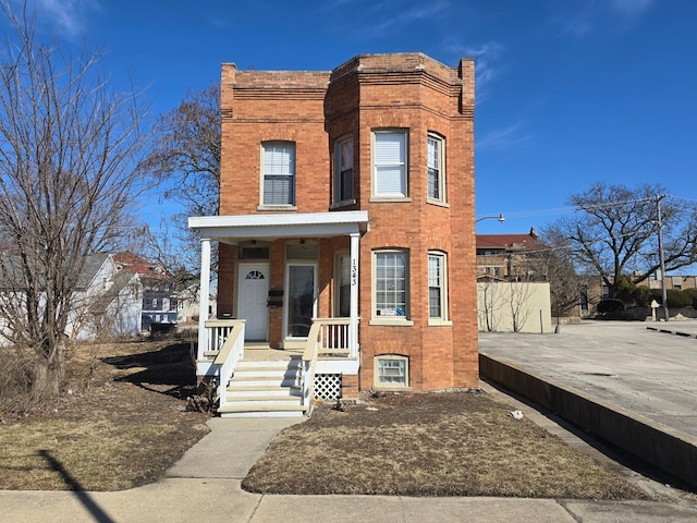 view of front facade featuring a porch and brick siding