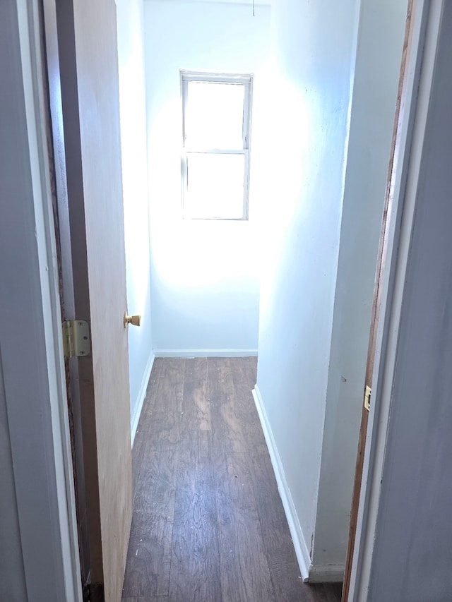 hallway with baseboards and wood finished floors