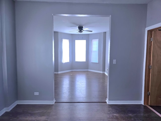 unfurnished room featuring ceiling fan, wood finished floors, and baseboards