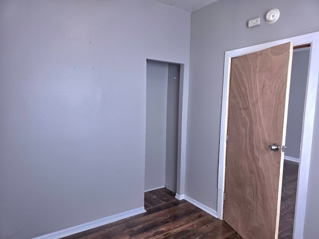 interior space with dark wood-style flooring and baseboards