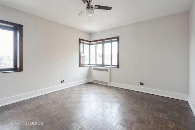 spare room with radiator heating unit, baseboards, and ceiling fan