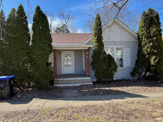 view of front facade featuring covered porch and a shingled roof