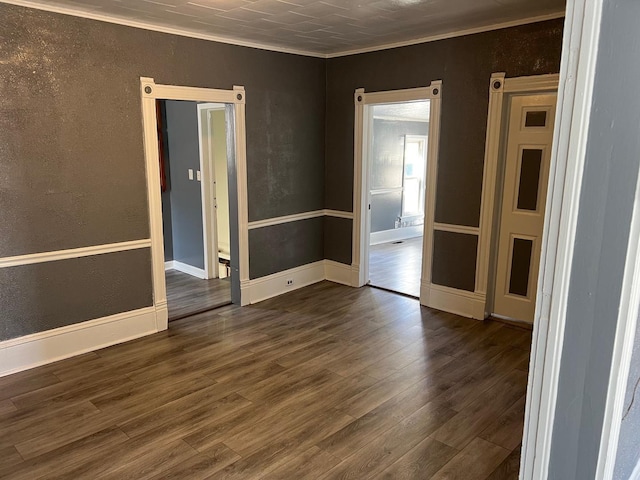 unfurnished room with crown molding, a textured wall, and dark wood-style flooring