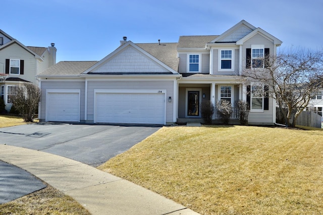 view of front of home featuring an attached garage, a front lawn, and aphalt driveway