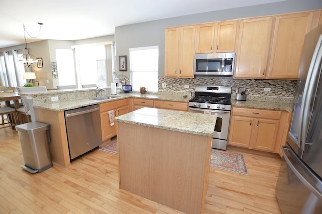 kitchen featuring stainless steel appliances, light brown cabinets, and a sink