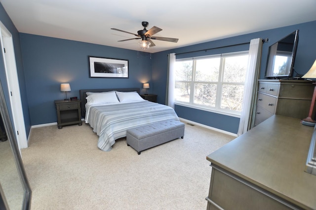 bedroom featuring light colored carpet, ceiling fan, and baseboards