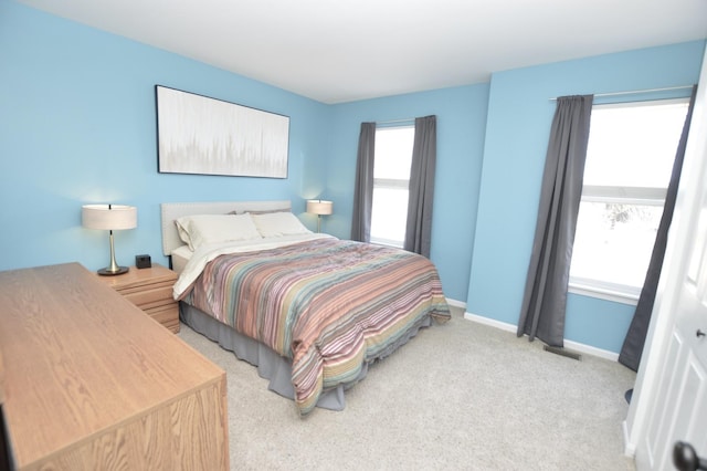 bedroom with light colored carpet, visible vents, and baseboards