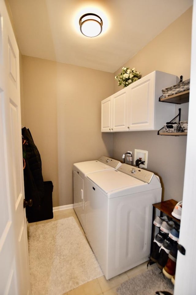 laundry room with light tile patterned floors, washer and clothes dryer, and cabinet space