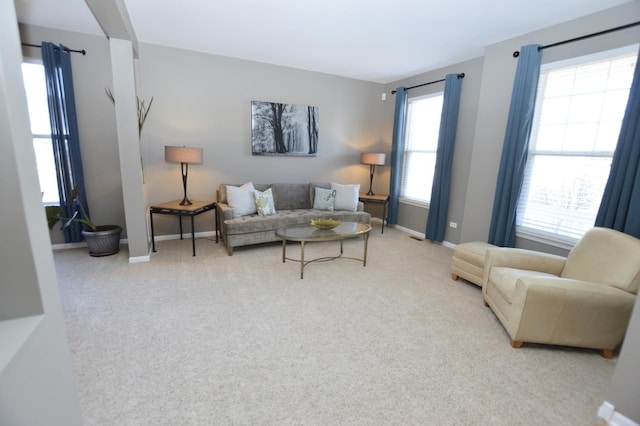 carpeted living area featuring baseboards