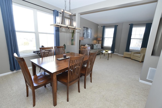 dining area featuring visible vents, a notable chandelier, light carpet, and baseboards