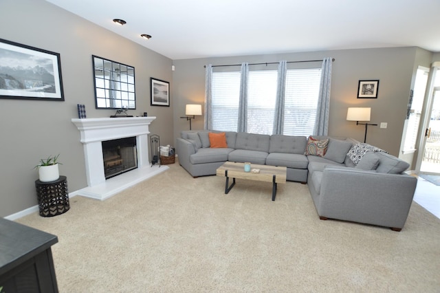 living area with baseboards, carpet flooring, and a glass covered fireplace