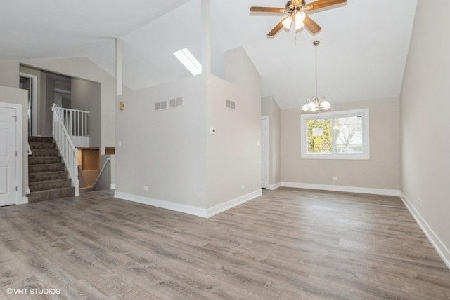 unfurnished living room featuring stairway, wood finished floors, visible vents, and baseboards