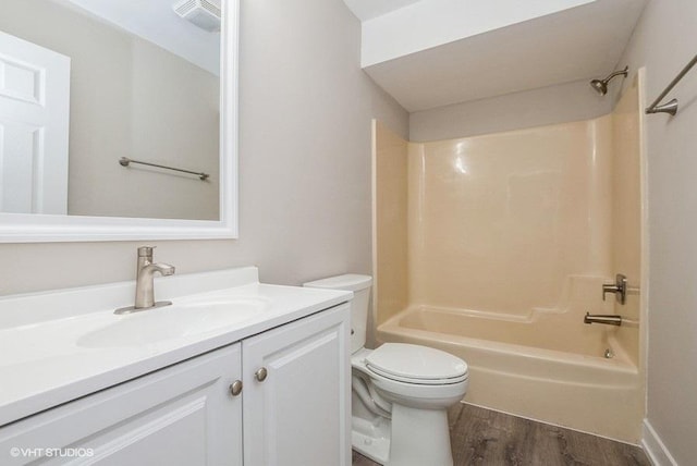 bathroom with vanity, shower / washtub combination, wood finished floors, and toilet