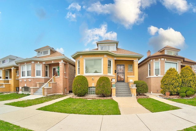 bungalow featuring brick siding and a front yard