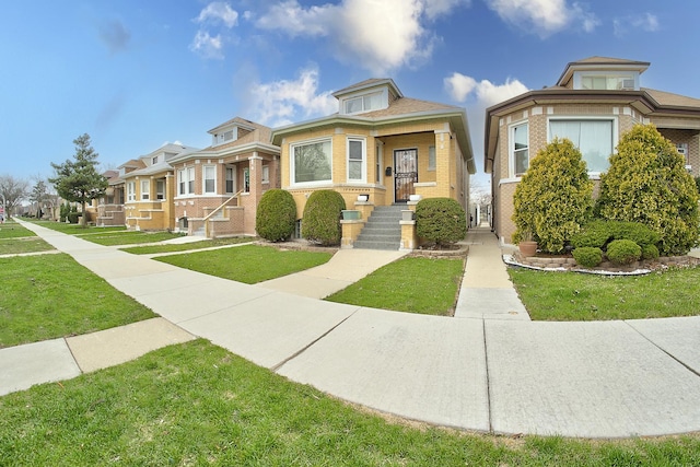 bungalow with a front yard and brick siding